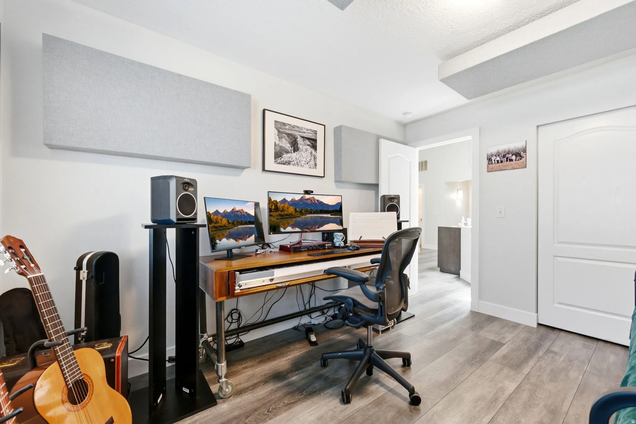 Dedicated workspace featuring wood-finish flooring, white walls, and a recessed light fixture