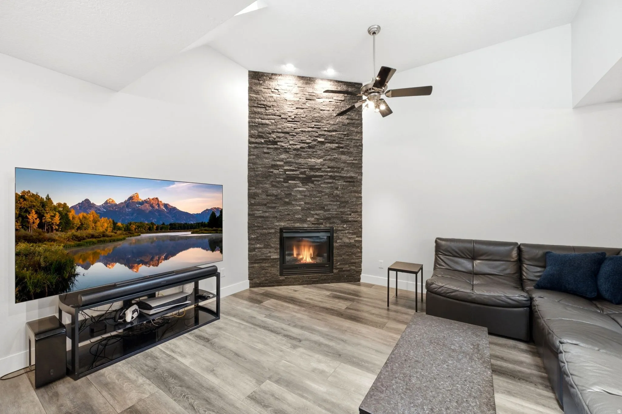 Corner fireplace featuring stacked stone surround