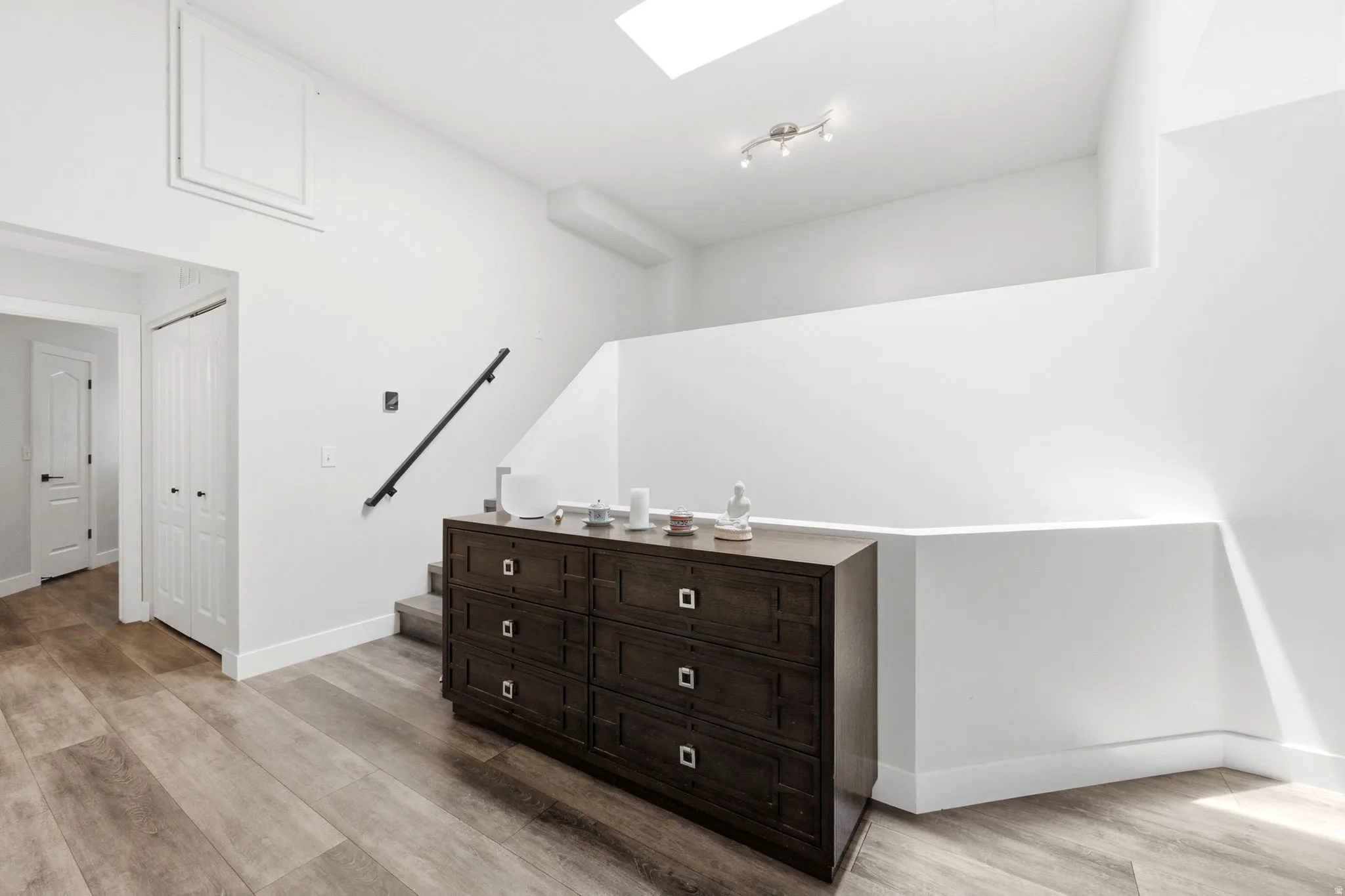 Warm wood-finish flooring complements the crisp white walls and white baseboards