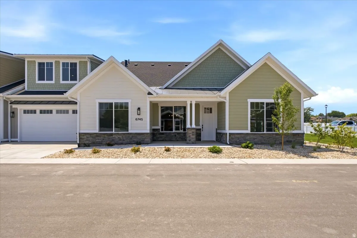 Contemporary ranch-style exterior with a two-car garage, stone façade accents, and a covered entry