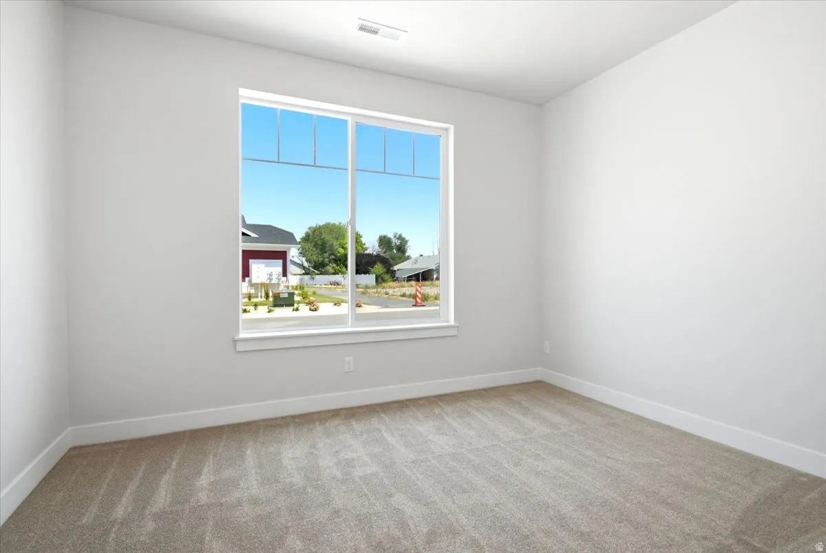 Room featuring a large window, light-colored walls, and neutral carpet