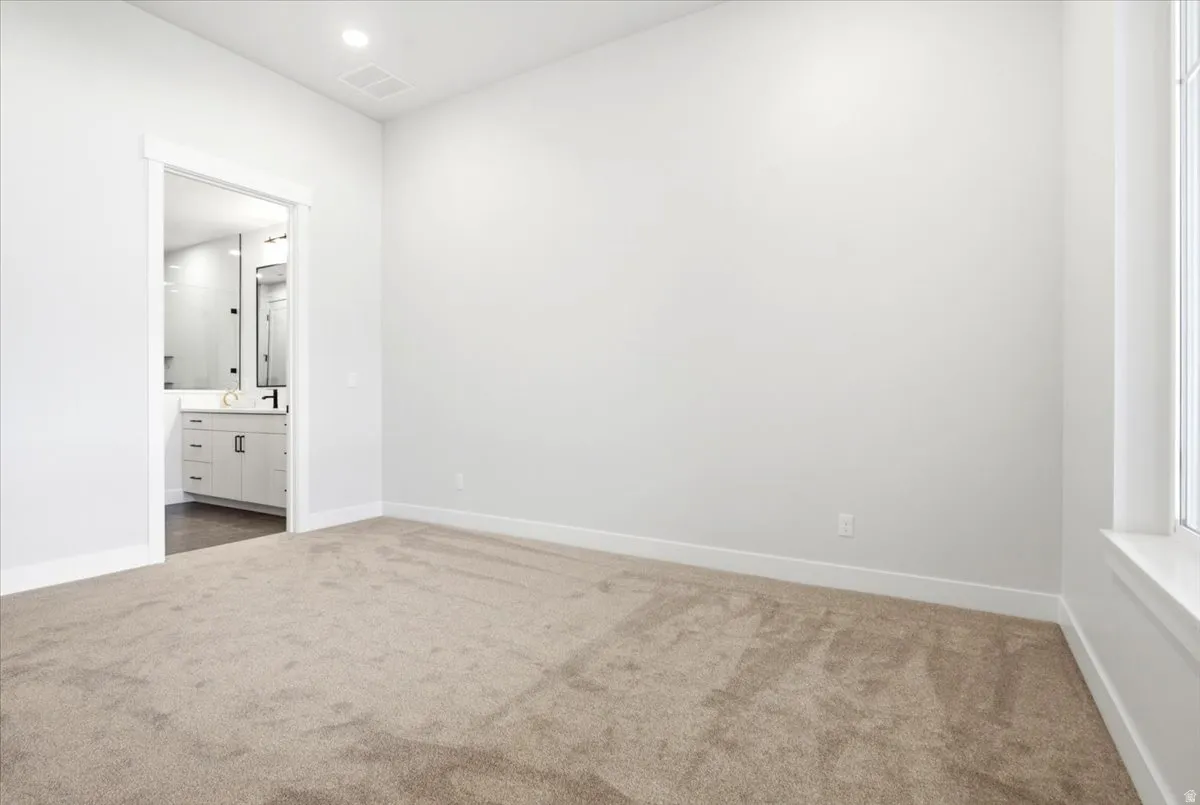 Spacious room featuring neutral carpeting and light-toned walls