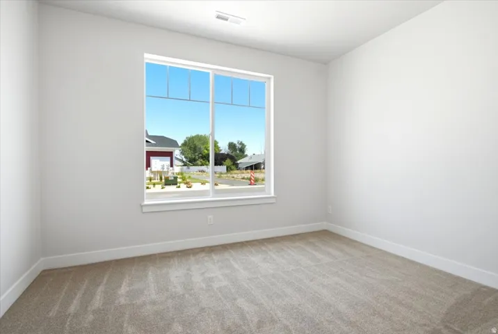 Room featuring a large window, light-colored walls, and neutral carpet