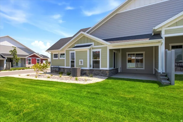 Exterior featuring siding in two tones, dark shingle roofing, and a covered patio with concrete flooring