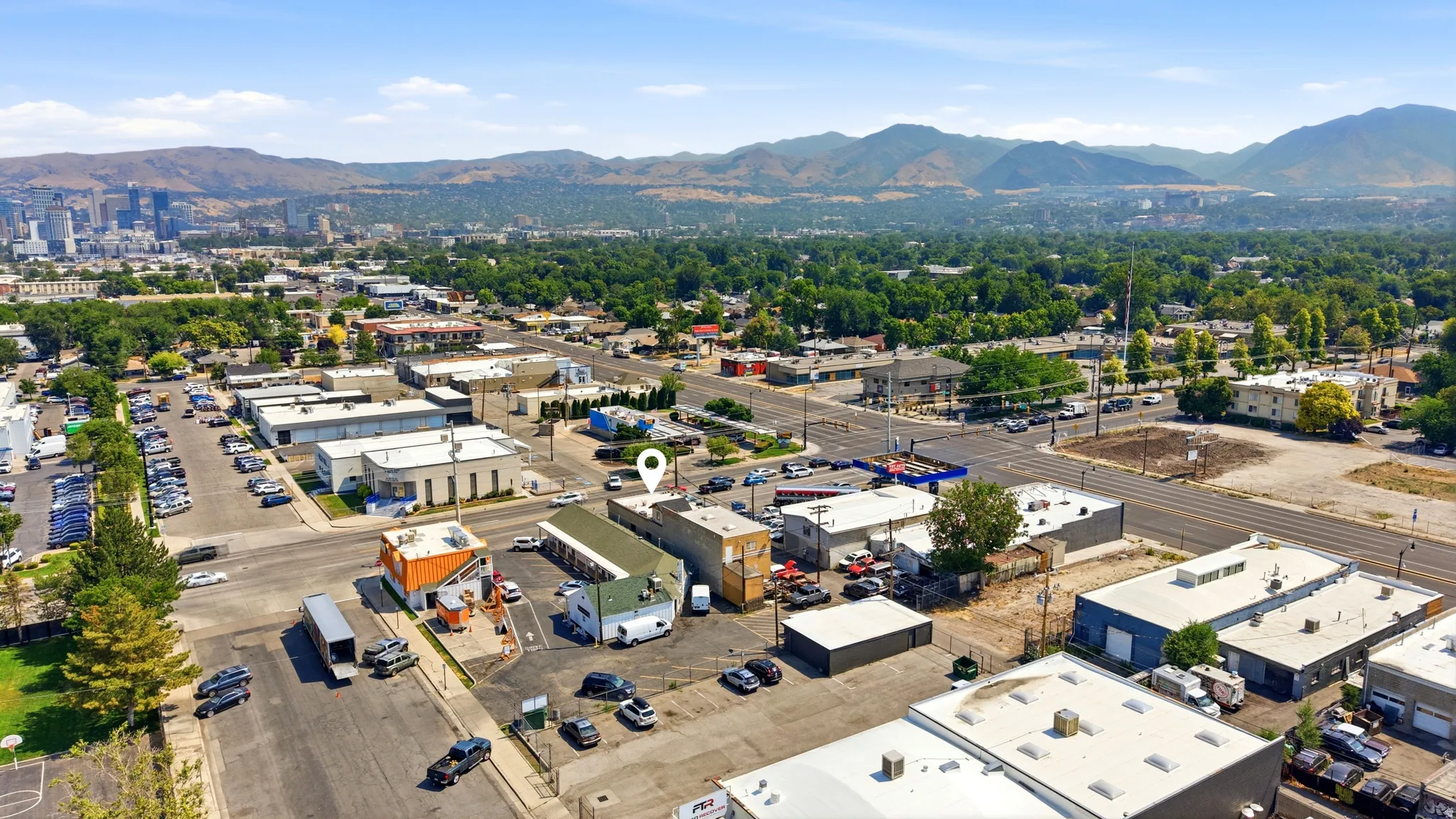 Aerial perspective showcasing commercial properties with surrounding mountains and urban skyline