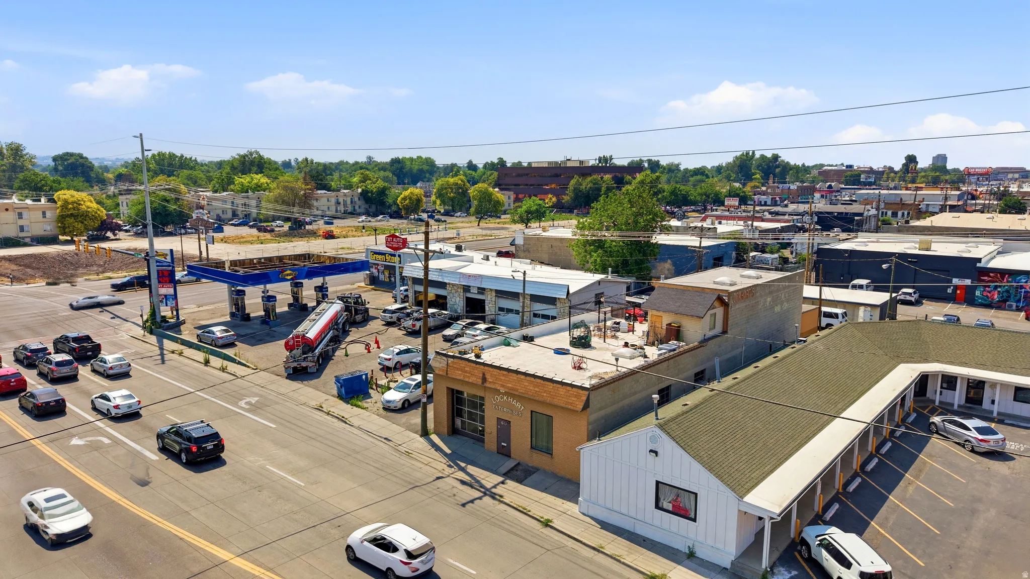 Commercial property featuring a gas station with multiple pumps, adjacent service bays, and a brick-front building