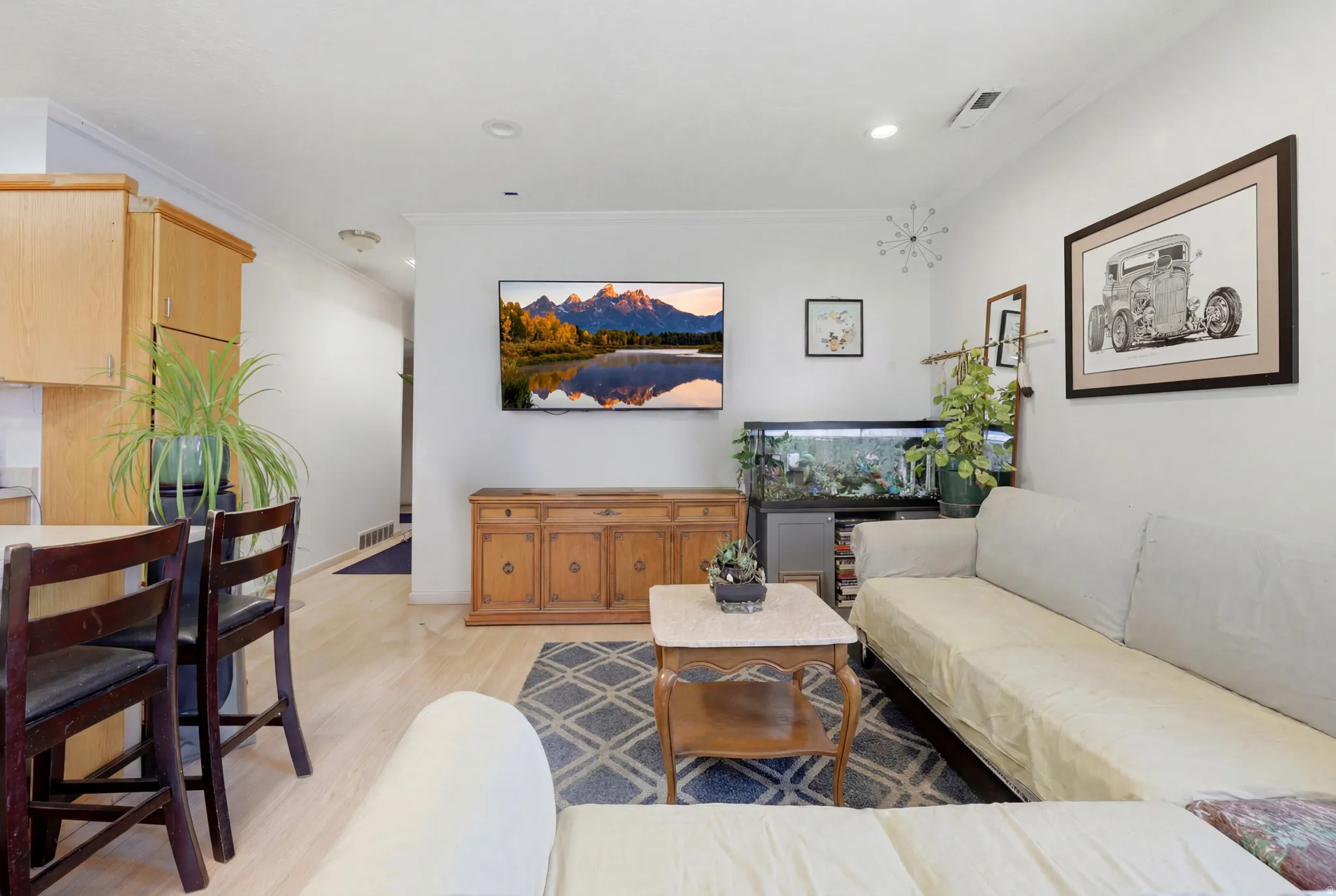 Living area featuring light wood-finish flooring, recessed lighting, and a neutral wall palette
