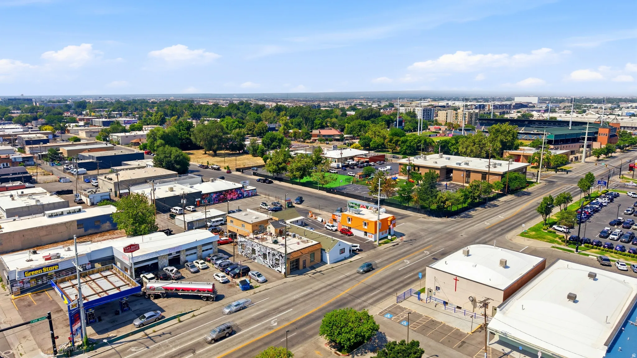 Urban commercial area featuring multiple buildings, paved roads, and various businesses