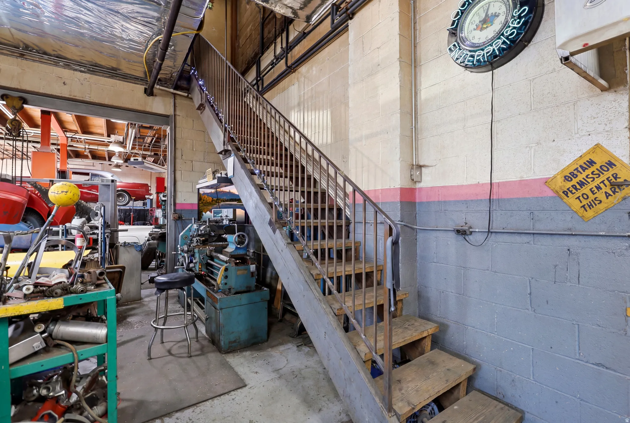 Industrial space featuring block walls, a durable concrete floor, and an open metal staircase with wood treads
