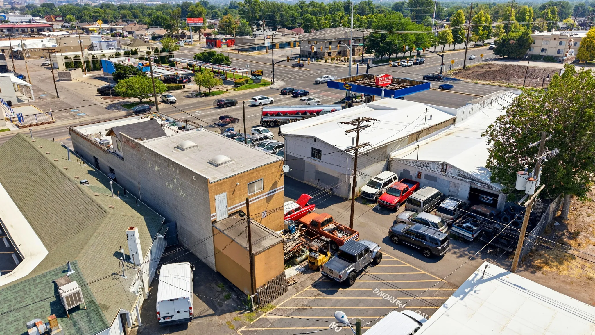 Commercial property with multiple buildings, paved parking areas, and mature trees