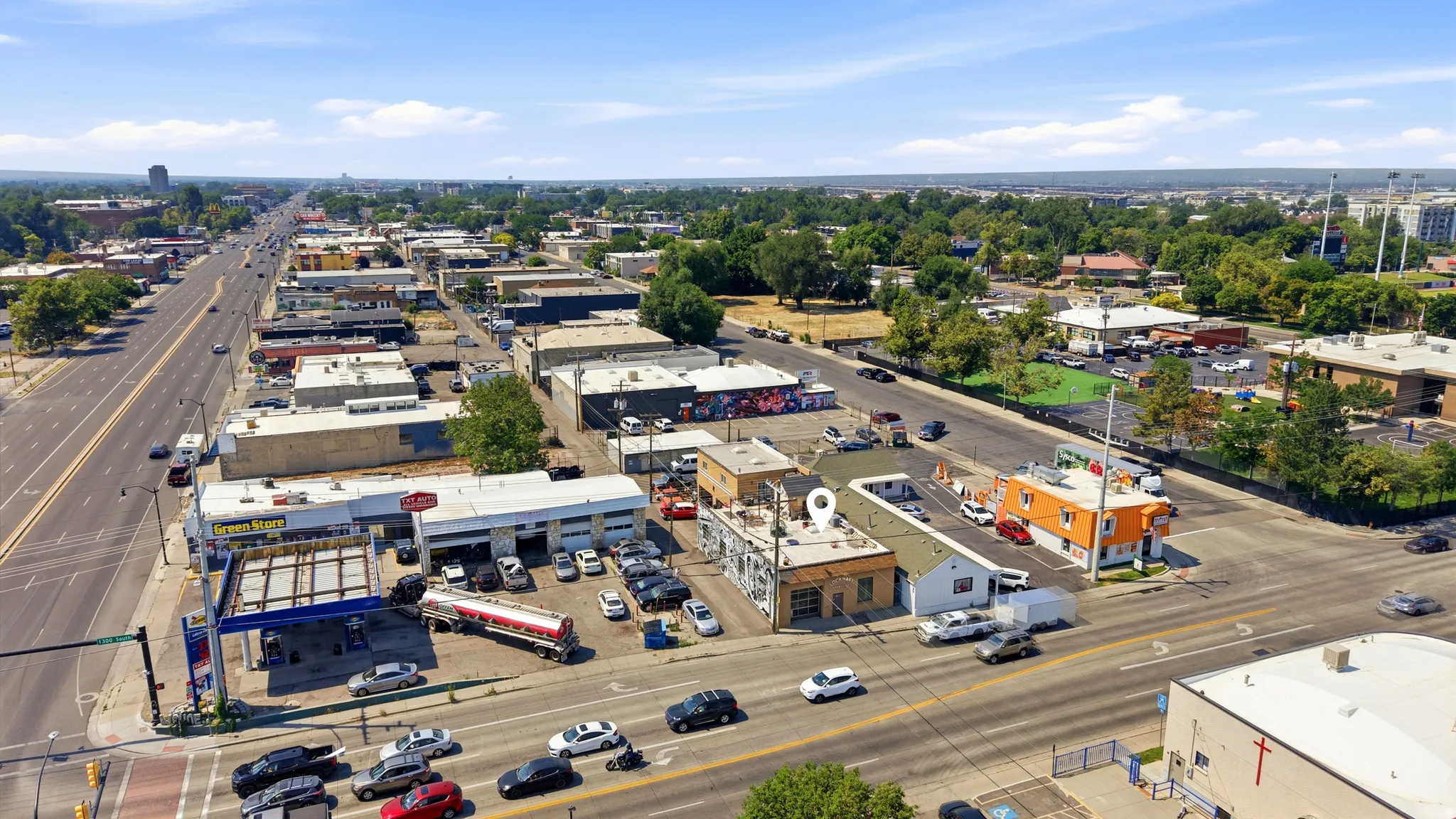 Commercial property featuring multiple buildings, paved parking, and direct frontage on a major thoroughfare