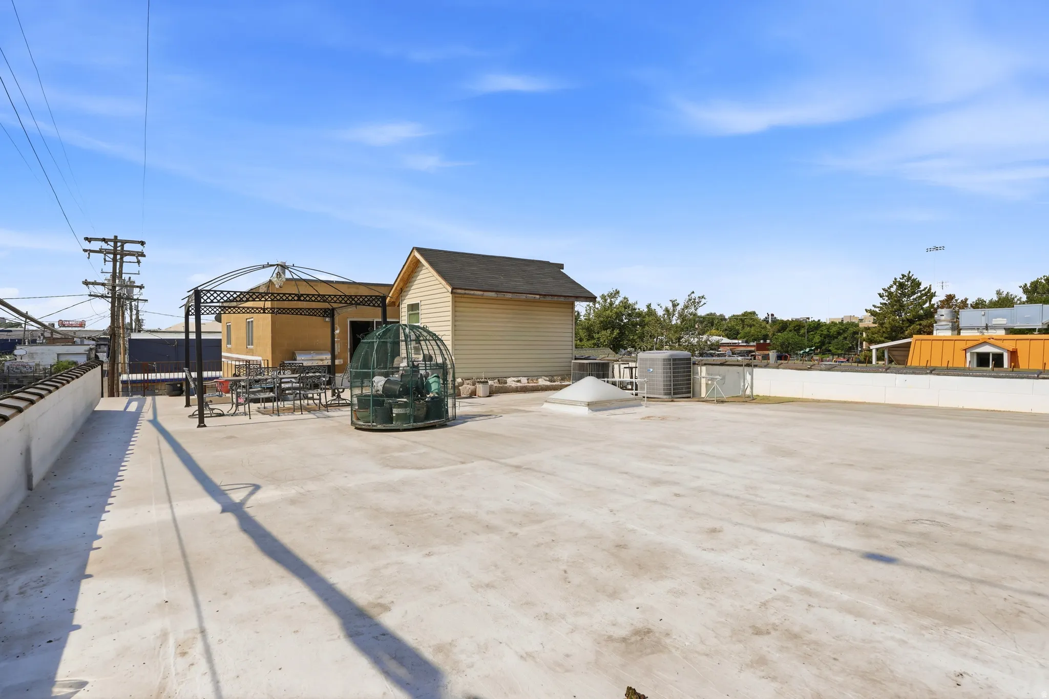 Expansive rooftop deck featuring a built-in metal gazebo and an integrated skylight