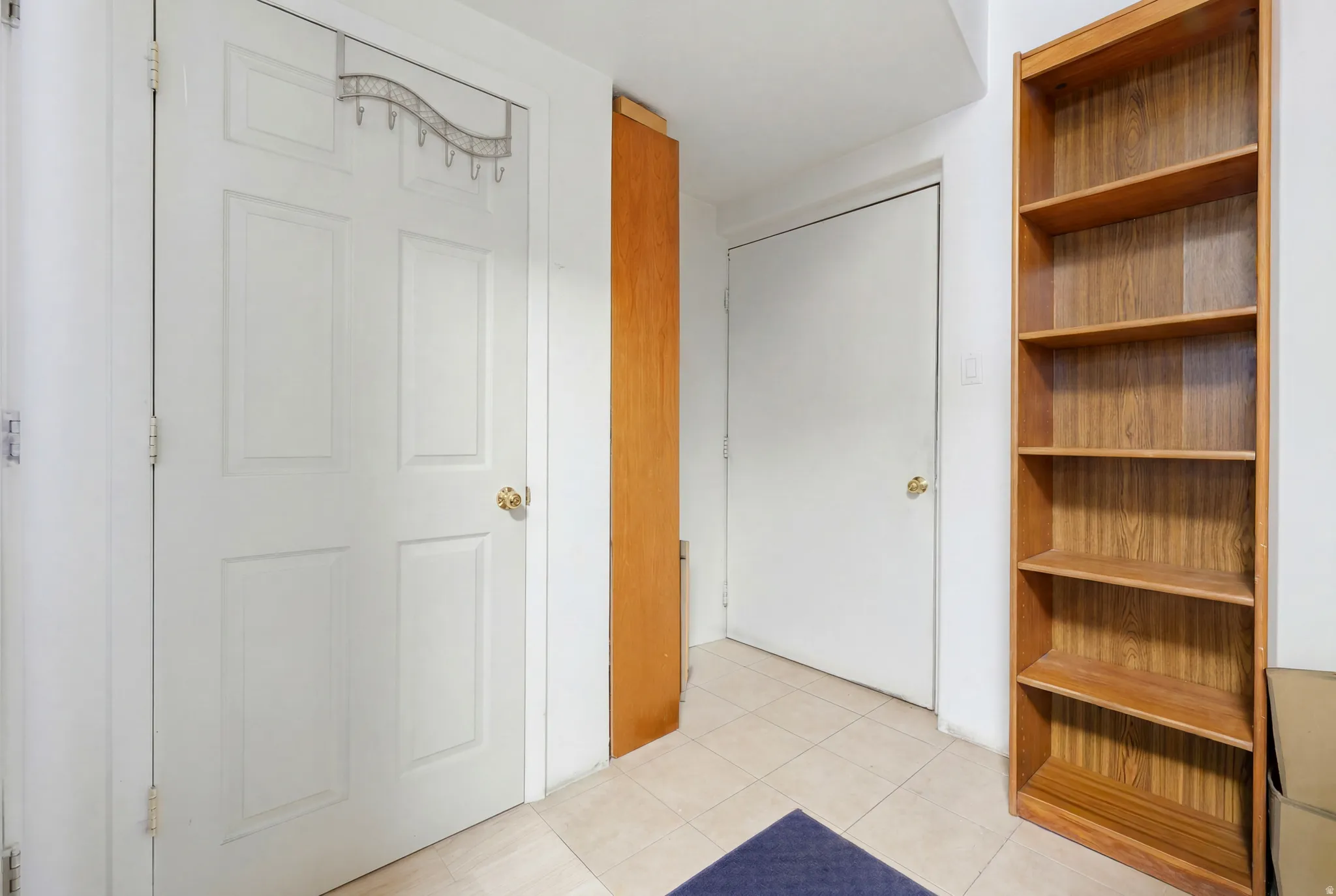 Tiled flooring complementing white panel doors and a wood-finish bookcase