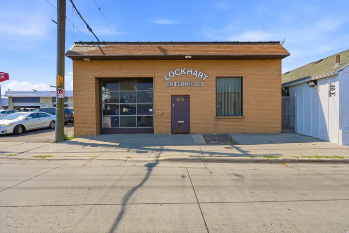 Single-story commercial building featuring a brick exterior and a brown shingle roof