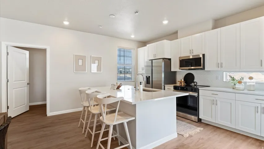 Modern kitchen featuring white shaker-style cabinetry and a central island with a countertop