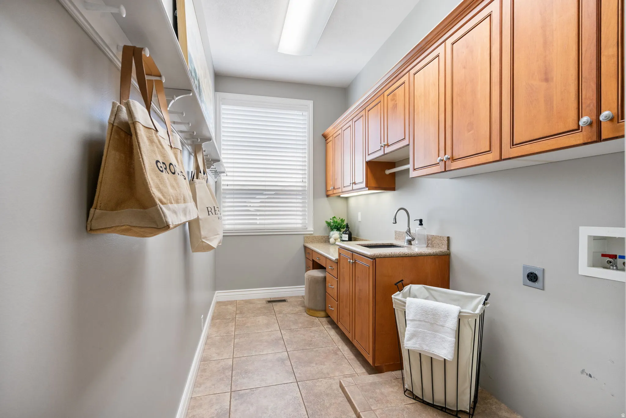 Dedicated main level laundry / mudroom has a built-in sink with a gooseneck faucet, ample hooks & 2 closets makes storing outwear easy and convenient.
