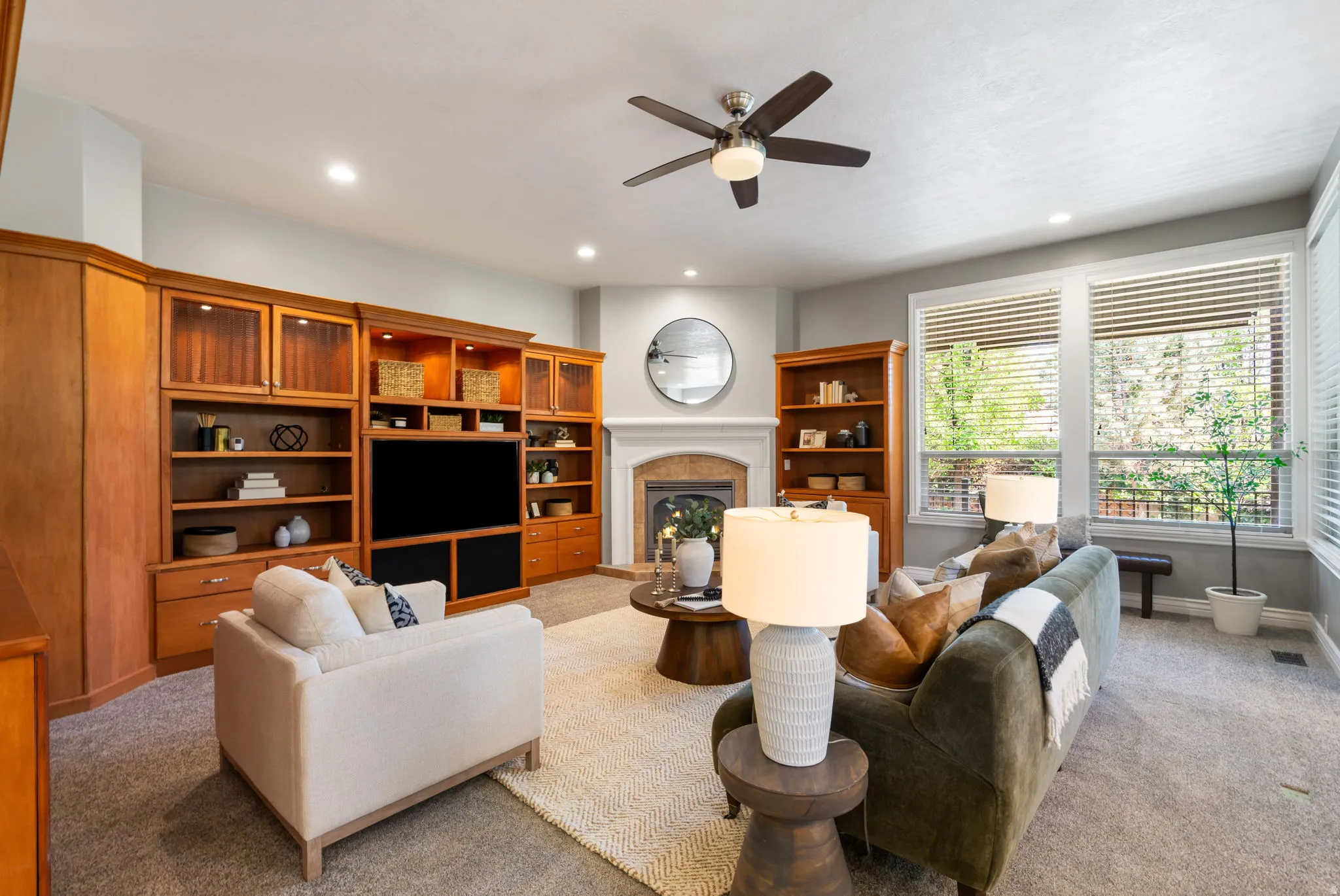 Living area has extensive built-in cabinetry and shelving, beautiful fireplace with stone mantel, oversized windows for abundant natural light.