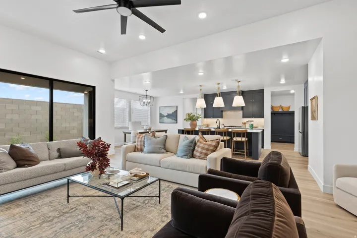 Open-concept living area with light wood-finish flooring, recessed lighting, and a modern ceiling fan