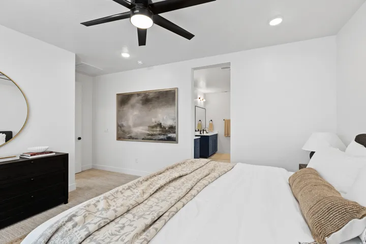 Spacious bedroom with a ceiling fan featuring integrated lighting and recessed ceiling lights