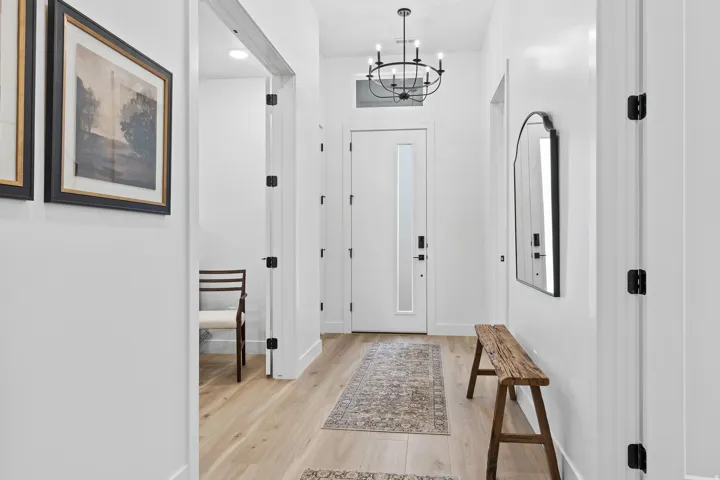 Entryway featuring a contemporary chandelier, light wood-finish flooring, and white walls