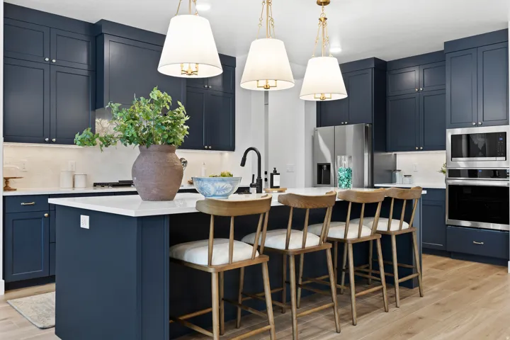 Kitchen featuring blue shaker cabinetry, a central island with countertop seating, stainless steel appliances, white countertops, and wood-finish flooring