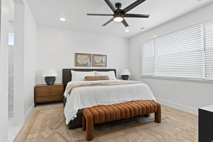 Bedroom featuring a ceiling fan with integrated lighting, recessed lighting, and a large window with blinds