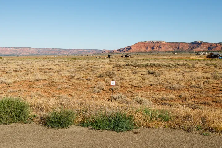 Expansive undeveloped land featuring natural vegetation and a distant mesa backdrop