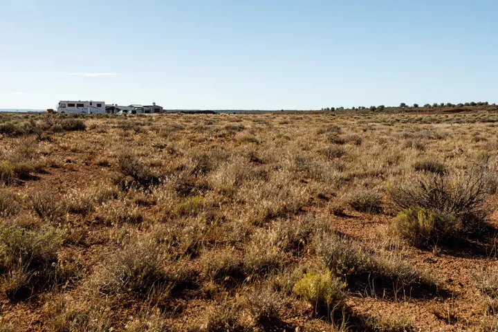 Expansive undeveloped land featuring natural desert flora and a flat topography under a clear sky