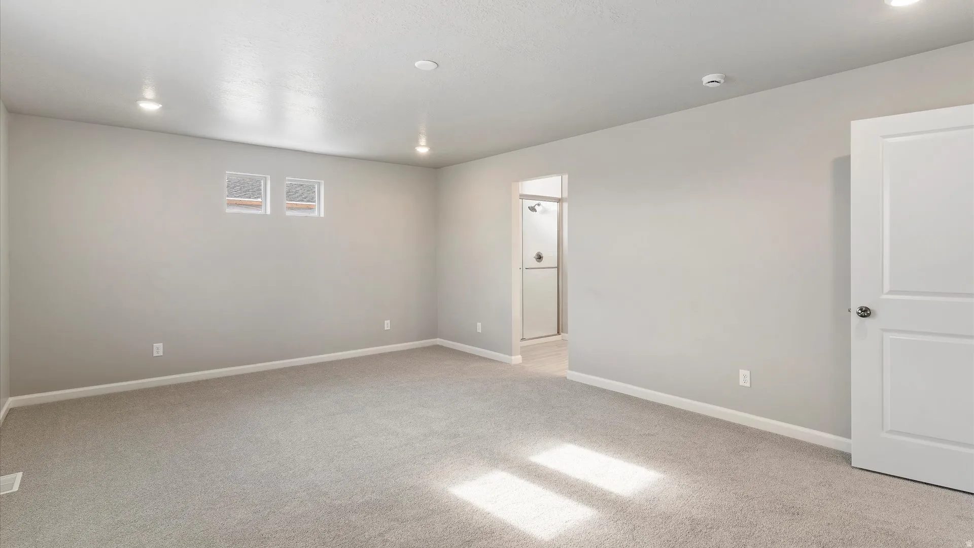 Carpeted room with recessed lighting and light gray wall paint