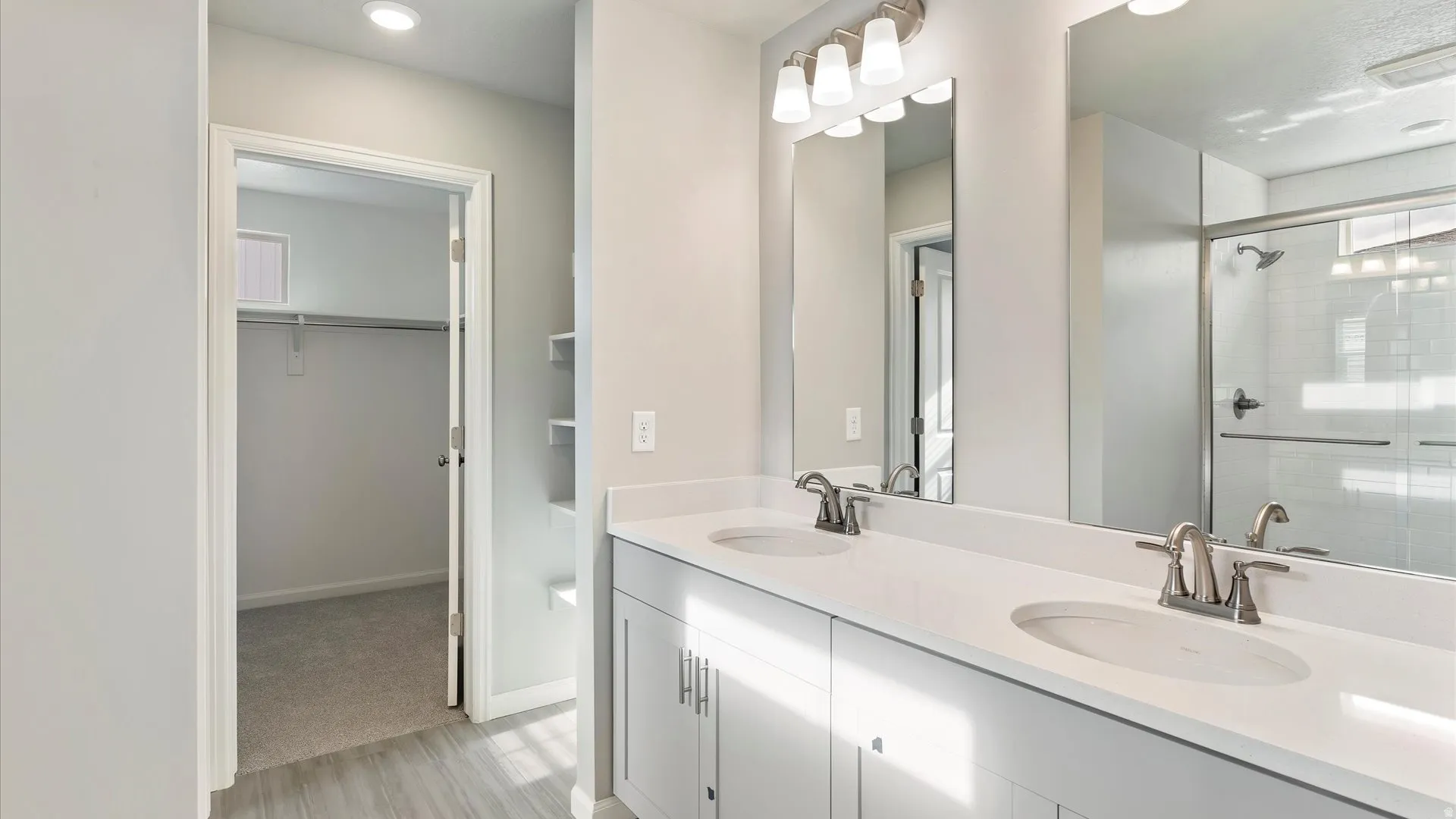 Dual vanity featuring integrated sinks, ample countertop space, and brushed nickel fixtures
