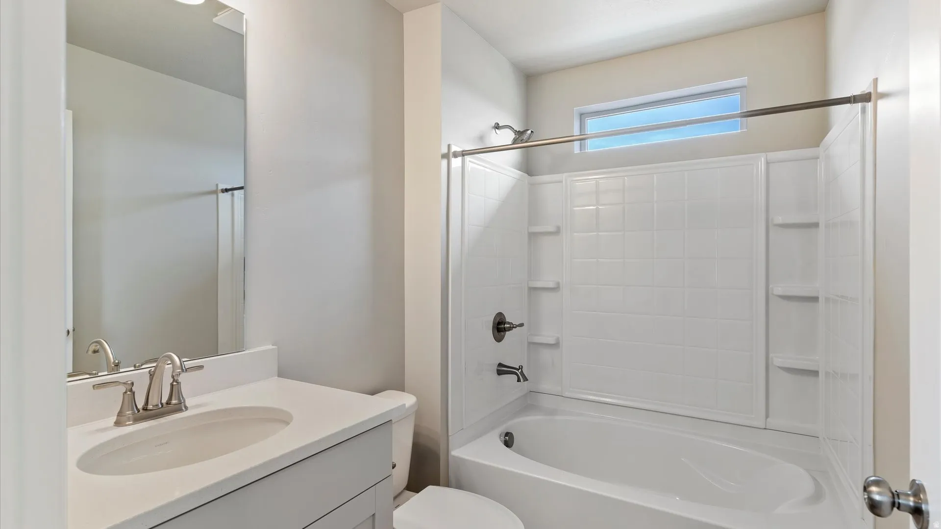 Bathroom featuring a white vanity with an undermount sink, brushed nickel faucet, and a large mirror