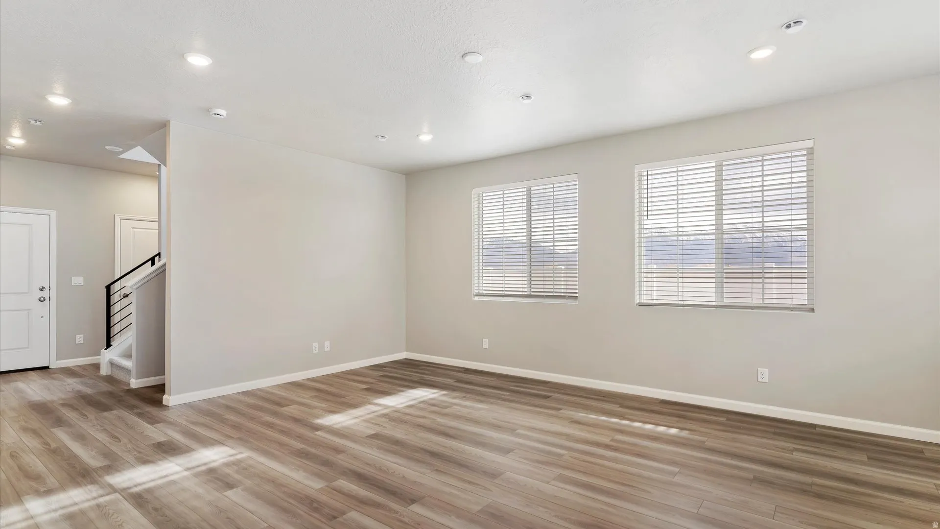 Spacious room featuring wood-finish flooring and neutral wall tones