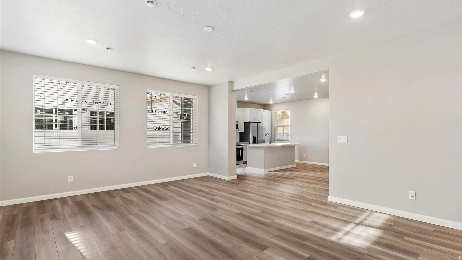 Spacious open-concept living area featuring wood-finish flooring and recessed lighting
