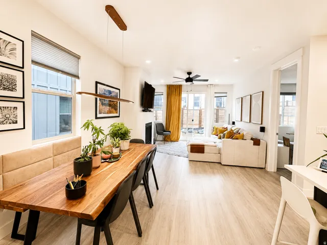 Open-concept living area featuring light wood-finish flooring, recessed lighting, and a modern linear chandelier