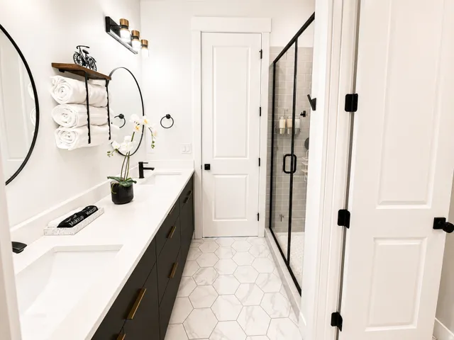 Double vanity featuring integrated rectangular sinks, white countertops, and matte black fixtures