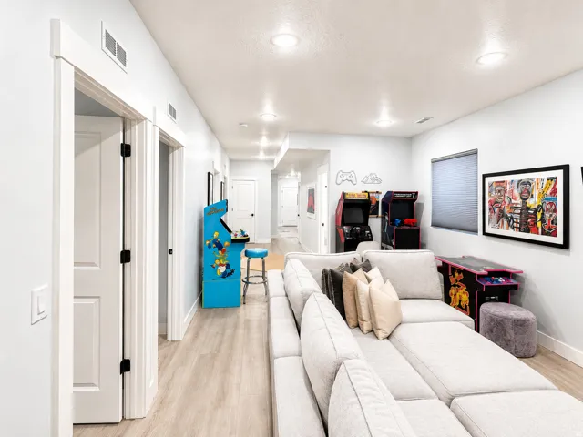 Open-concept space featuring light wood-finish flooring, recessed lighting, white trim, and doors with matte black hardware