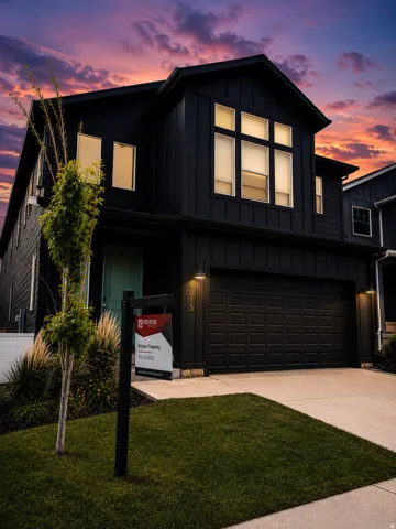 Modern two-story residence featuring a dark-toned exterior with vertical and horizontal siding