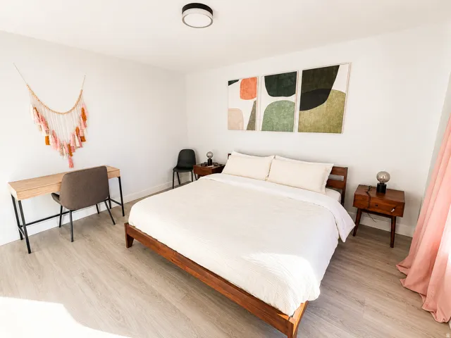 Light wood-finish flooring throughout, complemented by crisp white walls and a contemporary flush-mount ceiling light