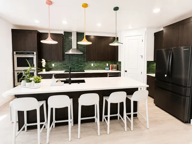 Modern kitchen featuring dark wood-finish cabinetry and a white countertop island
