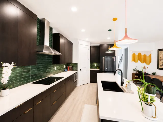 Modern kitchen featuring dark wood-finish cabinetry, white countertops, and a green subway tile backsplash