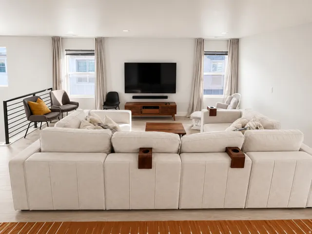 Open-concept living area featuring light wood-finish flooring, recessed lighting, and bright white walls