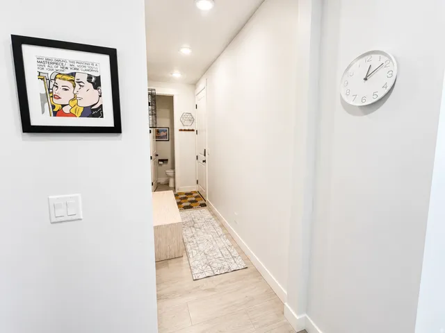 Bright hallway featuring recessed lighting, light-toned wood-finish flooring, and white baseboards
