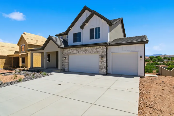 Contemporary two-story exterior featuring white board and batten siding, stone veneer accents, and a covered front porch