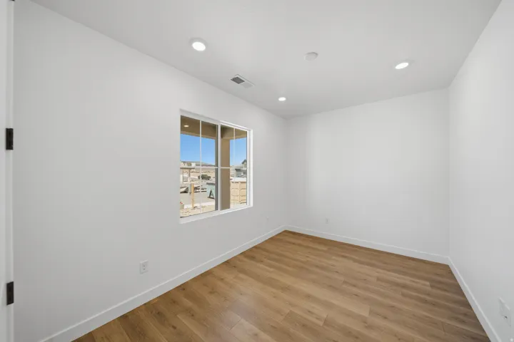 Interior room featuring wood-finish flooring and white baseboards