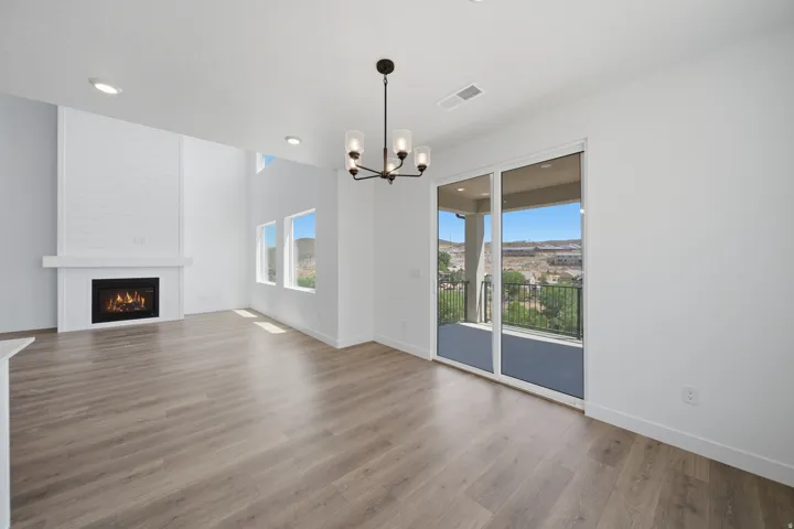 Spacious living area featuring light wood-finish flooring, a contemporary fireplace with a shiplap accent wall, and recessed lighting