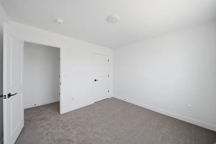 Neutral white walls complement the textured gray carpet