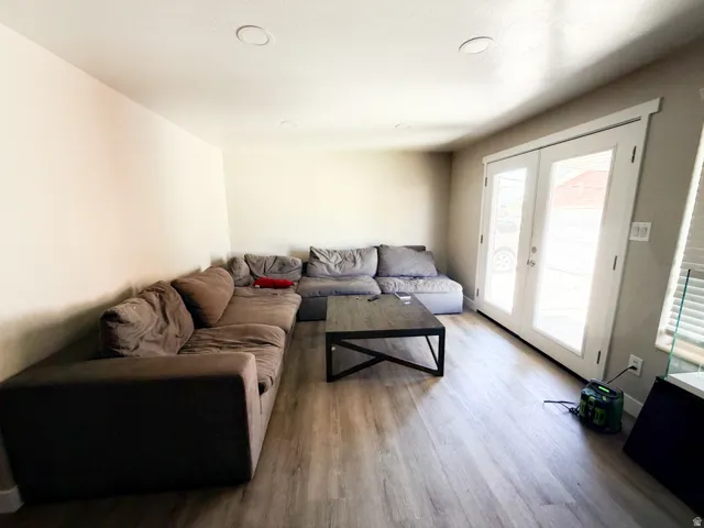 Spacious room featuring light wood-finish flooring, recessed lighting, and a neutral color palette