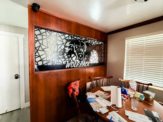 Wood-paneled room divider with a decorative metal insert