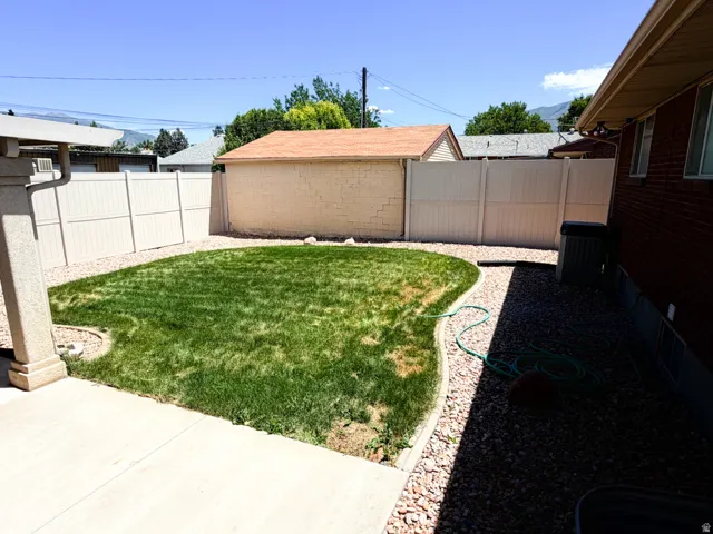 Landscaped backyard featuring a shaped lawn area, decorative gravel beds, and privacy fencing