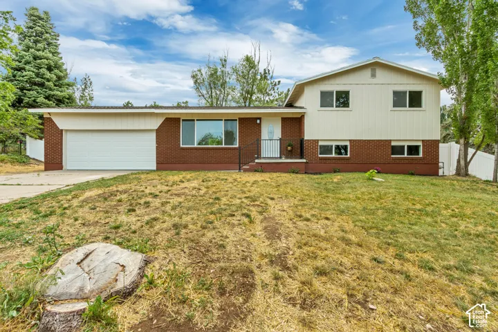 Split-level residence featuring brick and siding facade. New grass planted.